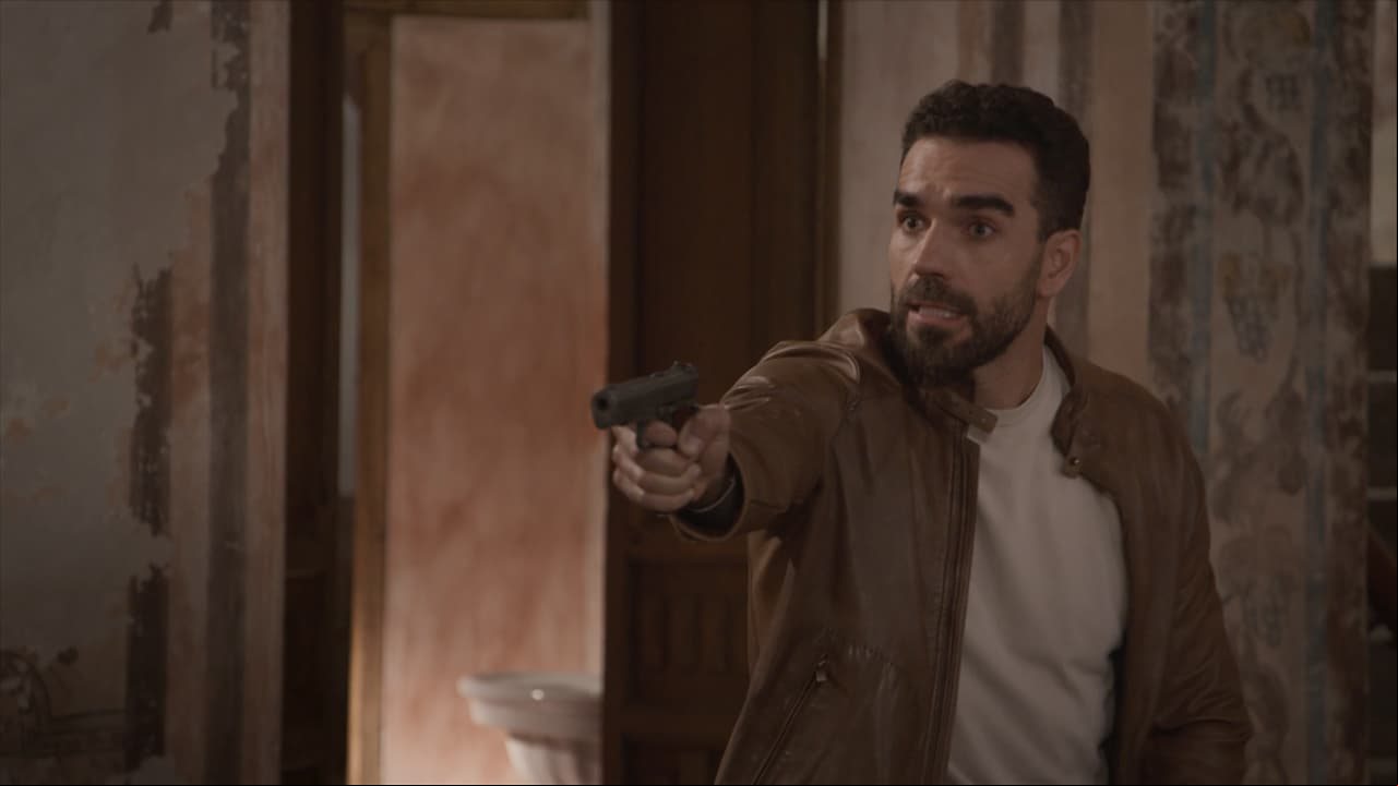 Le apunta a 'Rafael' con un arma para que libere a la mujer que ama.