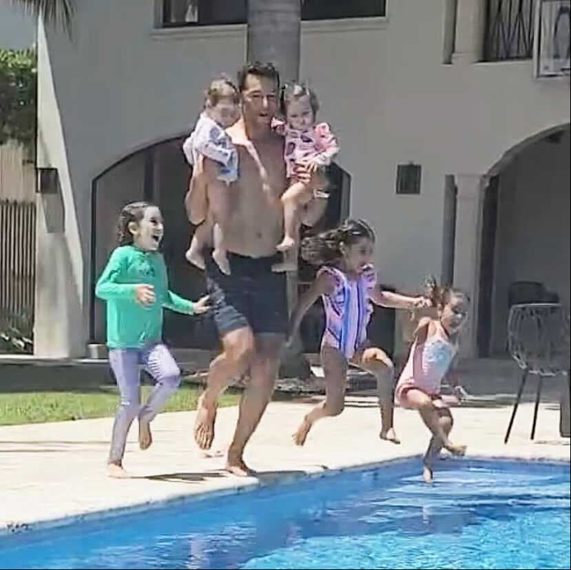 Las cinco niñas junto a su padre, listos para brincar a la alberca.