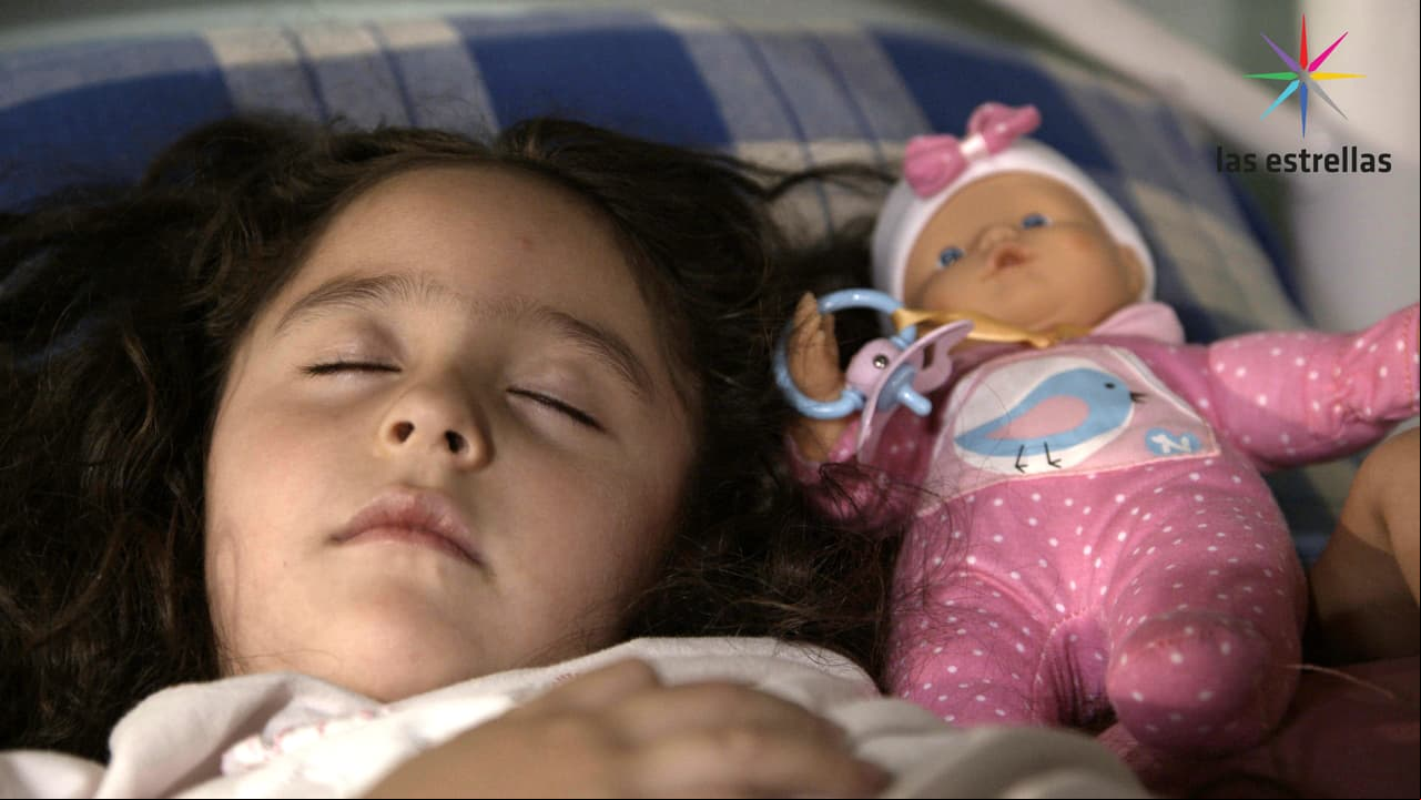 Alicia duerme acompañada de su muñeca favorita.
