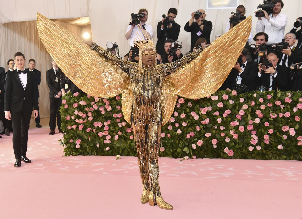 Billy Porter usó un traje dorado, que incluye alas y un casco de oro de 24 quilates, diseñado por Phillipe y David Blond.