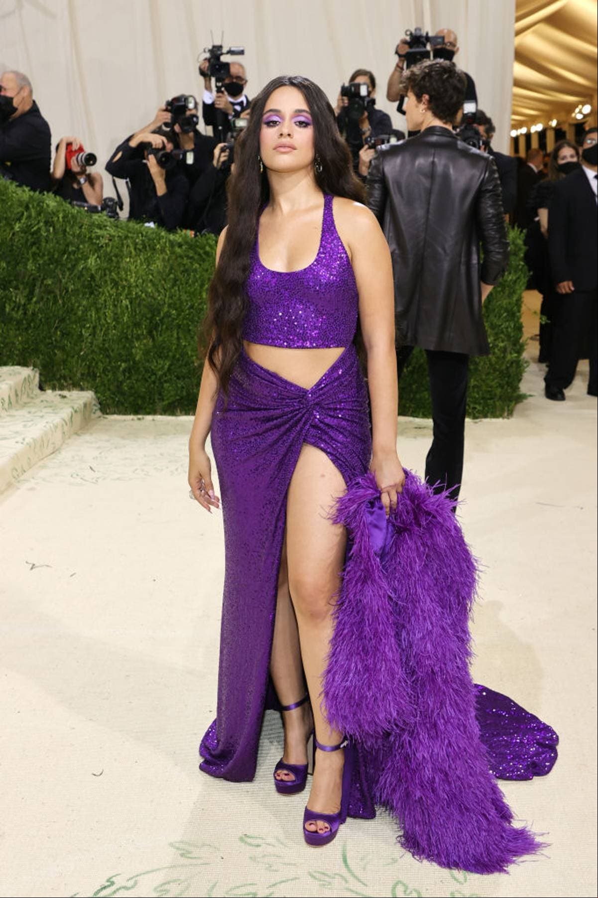 A su paso por el MET Gala 2021, Camila Cabello sorprendió con un vestido morado de dos piezas de la firma Michael Kors, el cual combinó perfecto con un abrigo de peluche y zapatillas moradas.