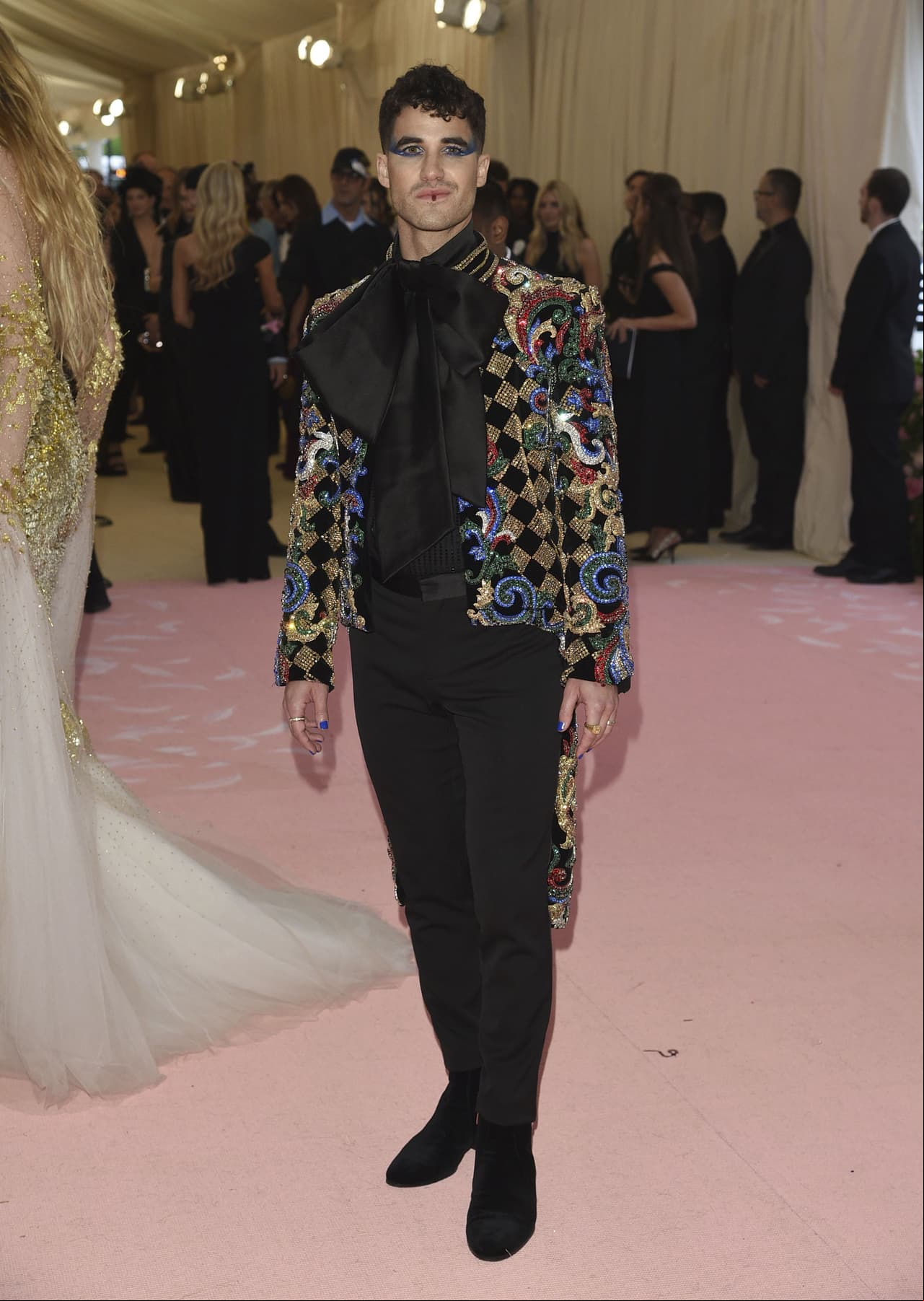Darren Criss muestra que los hombres también pueden correr riesgos en la alfombra roja al usar un poco de maquillaje en los ojos y lápiz labial.