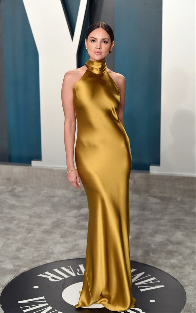 Eiza González fue una de las personalidades mejor vestidas del after party que organizó la revista Vanity Fair al lucir un slip dress de la firma Galvan London con cuello halter en un color dorado.