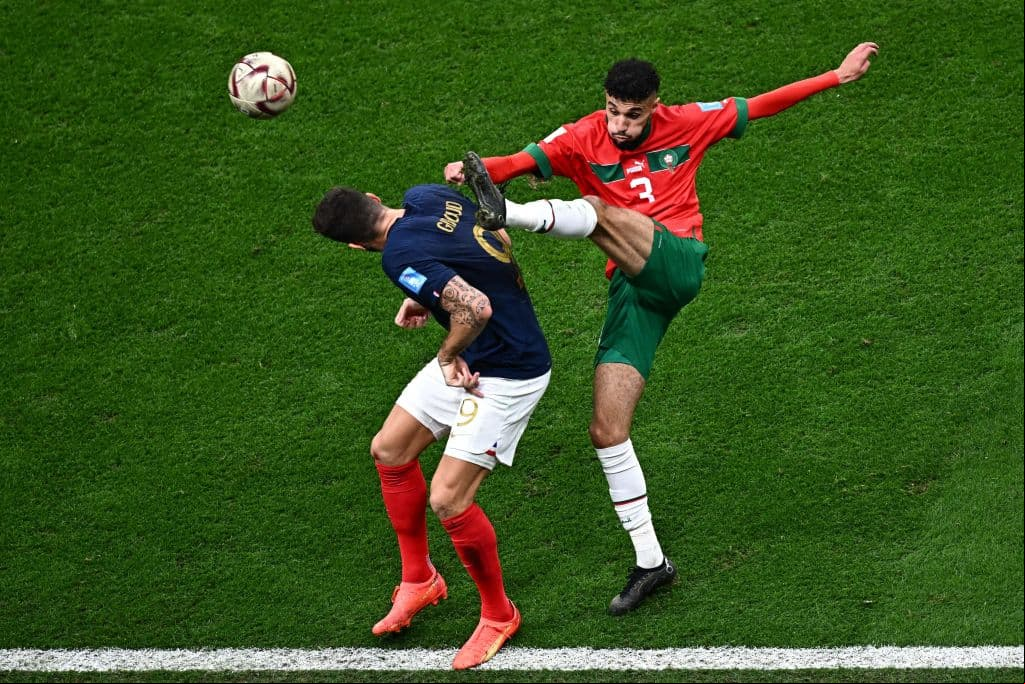 's forward #09 Olivier Giroud (L) and Morocco's defender #03 Noussair Mazraoui fight for the ball during the Qatar 2022 World Cup semi-final football match between  and Morocco at the Al-Bayt Stadium in Al Khor, north of Doha on December 14, 2022. (Photo by Anne-Christine POUJOULAT / AFP) (Photo by ANNE-CHRISTINE POUJOULAT/AFP via Getty Images)