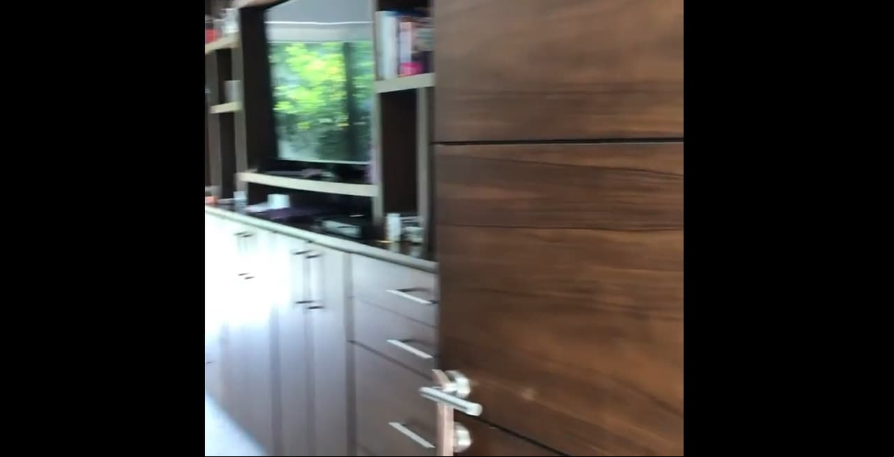 La decoración de su habitación es de muebles de madera, en los que se observa un centro de entretenimiento con una enorme televisión.