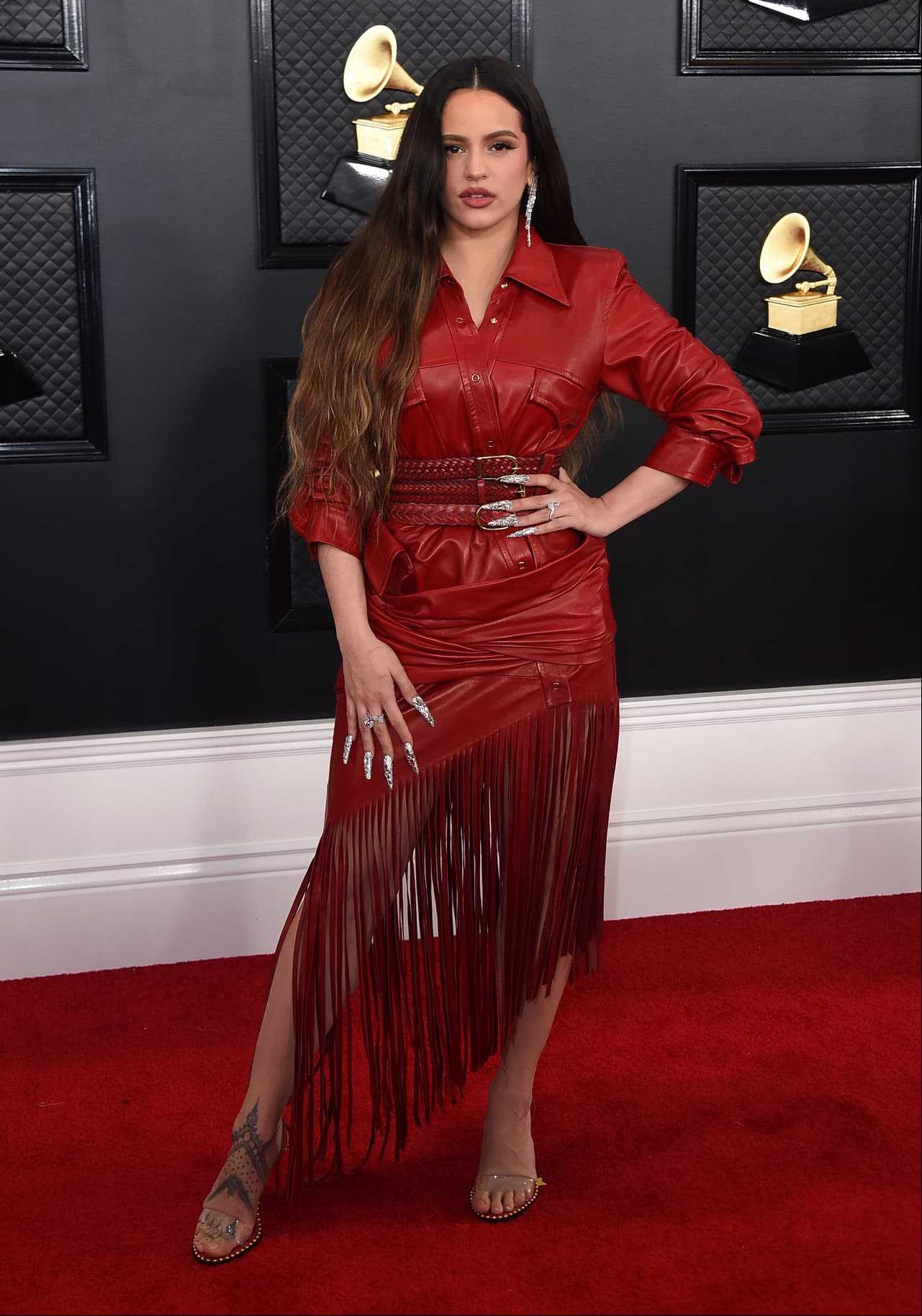 Con un outfit de cuero, Rosalía llegó a la alfombra roja. Su outfit es una creación del diseñador Alexander Wang. El modelo es asimétrico y con flequillos, todo en color rojo.