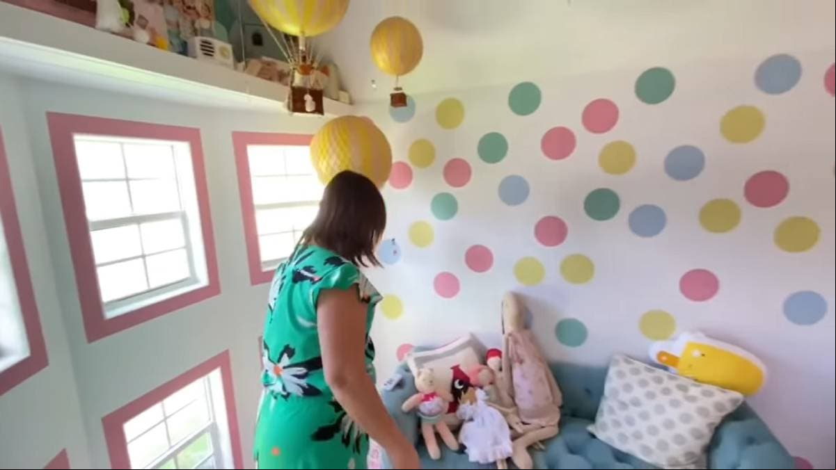 Además en la parte superior hay un juguetero y unos globos aerostáticos que cuelgan del techo; del otro lado se observa el aire acondicionado que tiene.